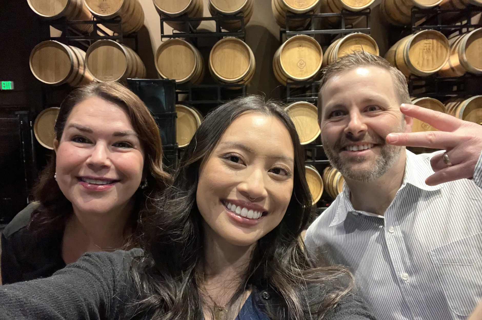 Three team members taking a selfie in a wine cellar