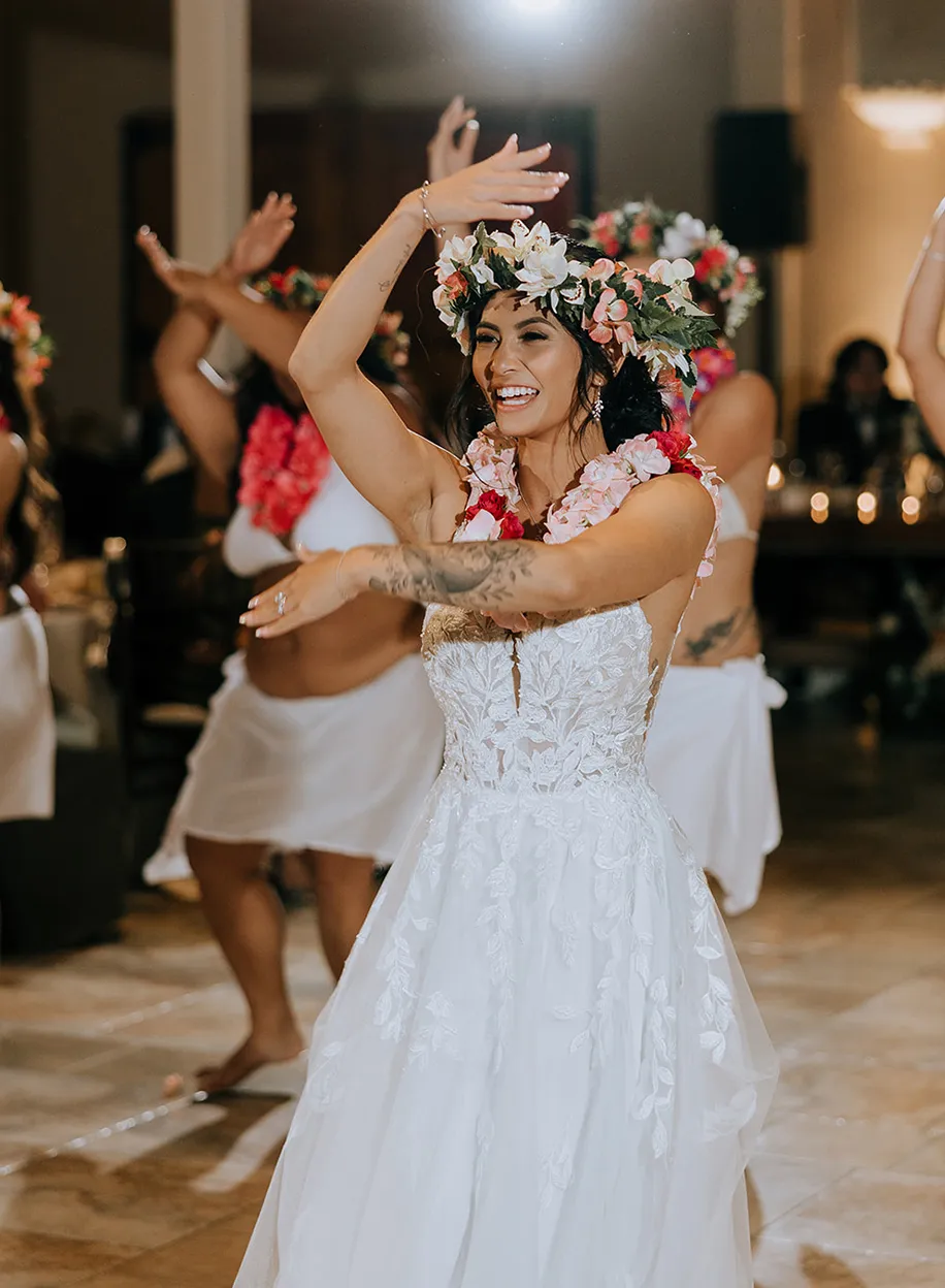 Bride wearing a floral crown performing a traditional dance at her reception
