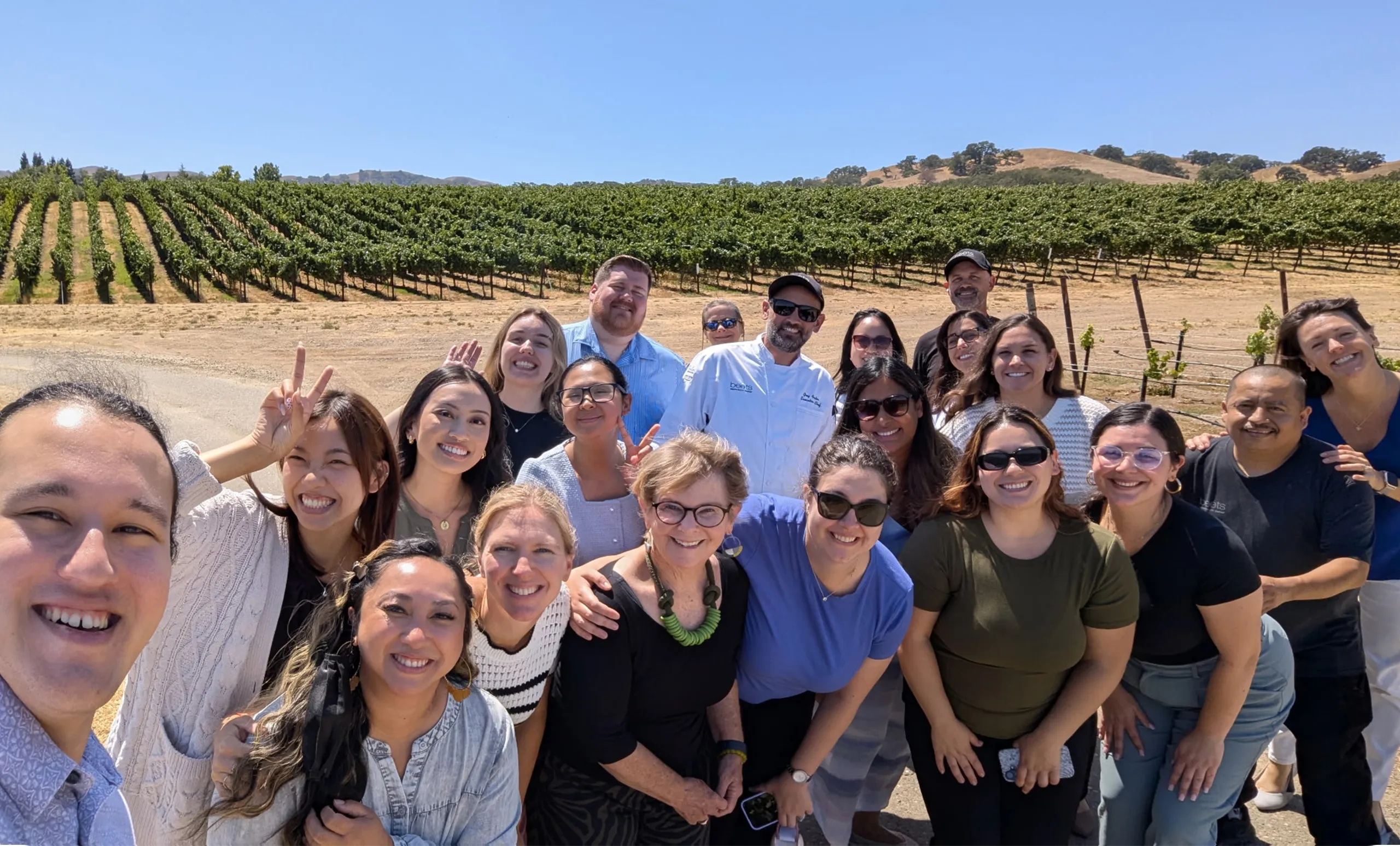 The Beets Hospitality team posing for a group selfie in the vineyard