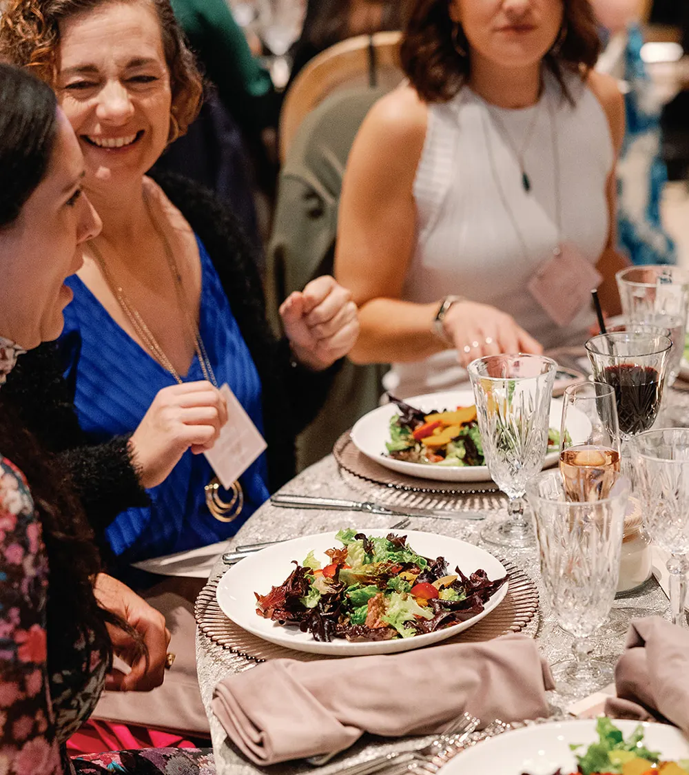 Guests laughing and enjoying dinner together at a corporate event
