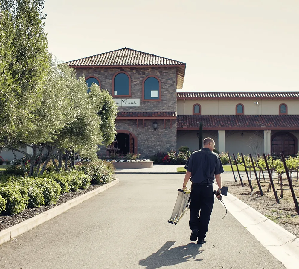 Team member carrying equipment along the walkway toward the Casa Real venue