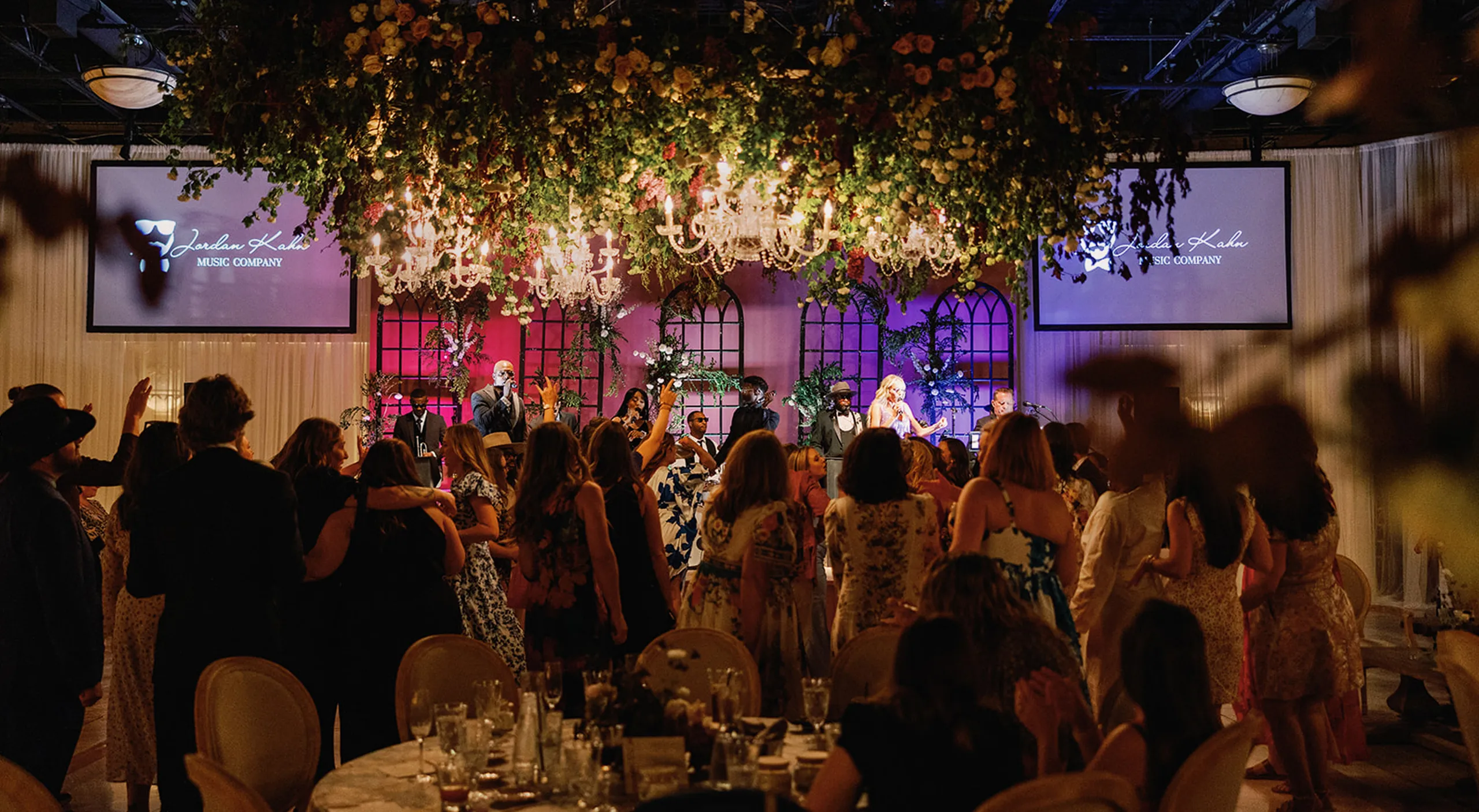 Corporate gala with live entertainment beneath floral chandeliers